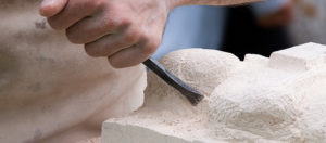 Mason carving out limestone